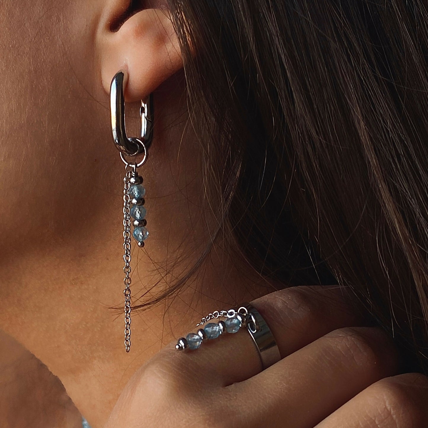 Hoop earrings with elegant dangle of blue topaz and chains in silver tone